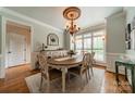 Formal dining room with chandelier, shuttered windows, and elegant decor at 3500 Maple Wood Dr, Denver, NC 28037