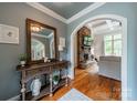 Entryway showcasing console table, mirror, hardwood floors, and archway to a living room at 3500 Maple Wood Dr, Denver, NC 28037