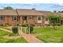 Charming brick home featuring manicured landscaping, a welcoming entrance, and an inviting front yard pathway at 402 Swaim Ct, Salisbury, NC 28147