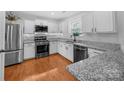 Bright kitchen with stainless steel appliances, granite countertops, and ample white cabinetry at 4113 Edgeview Dr, Indian Trail, NC 28079