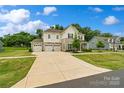 Attractive home with three-car garage, light exterior, and well-manicured lawn on a sunny day at 433 Sinaloa St, Waxhaw, NC 28173