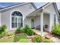 Inviting front porch with decorative wreath, bench, and lush landscaping at 4712 Avalon Forest Ln, Charlotte, NC 28269