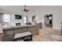 Bright living room featuring a fireplace, tv, ceiling fan, and wood-look flooring at 4712 Avalon Forest Ln, Charlotte, NC 28269