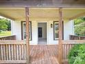 View of home's porch showcasing wooden railings, supports, and door leading inside at 502 E Main St, Cleveland, NC 27013