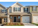 A charming townhome with a brick front, one car garage, and manicured landscaping in a modern color scheme at 5142 Tommy Ln # 1202, Stanley, NC 28164