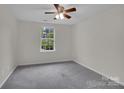 Neutral bedroom with a ceiling fan, a window and wall-to-wall carpet at 5237 Ficus Tree Ln, Charlotte, NC 28215
