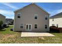The rear of the house with a gray facade and backyard including a concrete patio at 6614 Burkwood Ct, Harrisburg, NC 28075