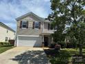 Charming two-story home with an attached garage and a well-manicured front yard at 6614 Burkwood Ct, Harrisburg, NC 28075