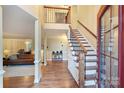 Bright foyer showcasing hardwood floors, staircase with wood and iron railing, and view into living room at 6722 Elmstone Dr, Charlotte, NC 28277