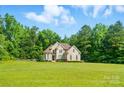 Stunning brick home with manicured lawn and mature trees, exuding curb appeal at 7006 Nesbit Rd, Waxhaw, NC 28173