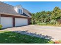 Spacious driveway leading to a three-car garage, offering ample parking and complemented by lush landscaping at 725 Old State Sw St, Concord, NC 28027