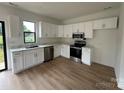 Modern kitchen features white cabinets, stainless steel appliances, and stylish countertops with views of the backyard at 760 3Rd Street Sw Pl, Hickory, NC 28602