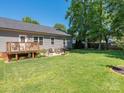 Large, well-manicured backyard featuring a wooden deck and an adjacent stone patio at 805 Brookmont Ave, Salisbury, NC 28146