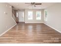 Spacious living room features natural light, neutral walls, ceiling fan and hardwood floors at 8432 Spirea Ct, Charlotte, NC 28215