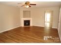 Living room with laminate flooring, fireplace, ceiling fan, and neutral paint at 8432 Spirea Ct, Charlotte, NC 28215