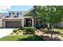 Charming single-Gathering home featuring a well-maintained front yard, stone accents, and an attached two-car garage at 9062 Treetop Nw Way, Concord, NC 28027