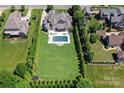 Expansive backyard featuring a sparkling pool, lush lawn, and meticulously maintained greenery at 9807 Aristides Dr, Waxhaw, NC 28173