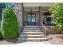 Charming entrance with stone steps, double doors adorned with wreaths, and stylish outdoor lighting at 9807 Aristides Dr, Waxhaw, NC 28173