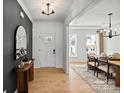 Inviting entryway with light wood floors, a dark accent wall, and views into the dining area at 1042 Waxhaw Crossing Dr # 262, Waxhaw, NC 28173