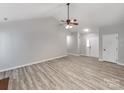 Open-concept living area with vaulted ceilings, fan, and natural light, showcasing neutral paint at 10736 Spruce Mountain Rd, Charlotte, NC 28214
