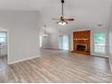 Spacious living room featuring vaulted ceilings, a brick fireplace, and wood-look flooring at 10736 Spruce Mountain Rd, Charlotte, NC 28214