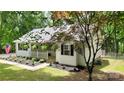 Cozy home with landscaped front yard, porch with hanging plants, and leafy surrounding trees at 109 Pepper Cir, Mooresville, NC 28117