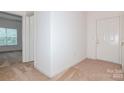 Neutral hallway featuring tile flooring, carpeted bedroom, and front door at 11863 Ridgeway Park Dr, Charlotte, NC 28277