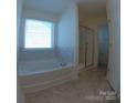 Bright bathroom featuring a soaking tub with tile surround and a glass-enclosed shower at 120 Mooring Dr, Statesville, NC 28677