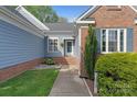 Inviting entrance featuring brick accents, well-maintained landscaping, and a charming walkway at 1310 Bellhook Nw Pl, Concord, NC 28027