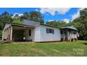Single story home with white siding, metal roof, covered entry, and well maintained lawn at 140 Dalu Ln, Harmony, NC 28634