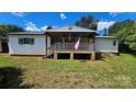 Inviting single story home with covered front porch, white railings, and American flag at 140 Dalu Ln, Harmony, NC 28634