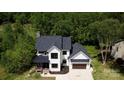Charming two-story home with black roof, white siding, and two-car garage, set amongst lush greenery at 1543 Withers Dr, Denver, NC 28037
