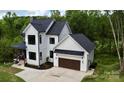 Stunning two-story home with white siding, black trim, and attached two-car garage on large lot at 1543 Withers Dr, Denver, NC 28037