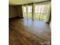 Open living area with sliding glass doors to the deck and laminate flooring at 1624 Arlyn Cir # G, Charlotte, NC 28213