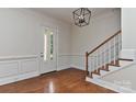 Open foyer featuring hardwood floors, elegant wainscoting, and a staircase with wooden banister at 17210 Sulky Plough Rd # 1206, Charlotte, NC 28277