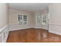 Bright living room featuring hardwood floors, classic wainscoting, and large windows at 17210 Sulky Plough Rd # 1206, Charlotte, NC 28277