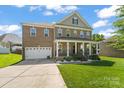 Charming brick home with a welcoming front porch, lush lawn, and two-car garage at 2213 Iron Works Dr, Clover, SC 29710