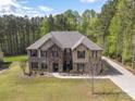 This two-story home is crafted with brick and stone and surrounded by lush greenery and a mature treeline at 240 Bells Crossing Dr, Mooresville, NC 28117