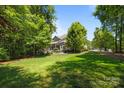 Large backyard featuring a lush lawn, mature trees and landscaping, and a patio set at 3009 Botetourt Ct, Weddington, NC 28104