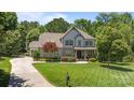 Charming two-story house with stone accents, a well-kept lawn, and a driveway leading to the garage at 3009 Botetourt Ct, Weddington, NC 28104
