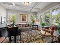 Cozy room with detailed coffered ceiling, piano, and comfortable seating with lots of natural light at 3009 Botetourt Ct, Weddington, NC 28104