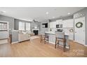 Bright, open-concept living room featuring wood floors, a fireplace, and access to the kitchen at 3013 Coventry Commons Dr, Mint Hill, NC 28227