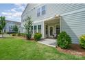 Back patio area with small awning and view of small yard and lush green landscaping at 355 Ladybird Ln, Pineville, NC 28134