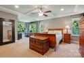 Spacious main bedroom with tray ceilings, a ceiling fan, lots of natural light, and hardwood furnishings at 3808 Halcyon Dr, Huntersville, NC 28078