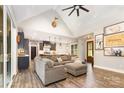 Inviting living room and kitchen with hardwood floors, vaulted ceilings, and a large comfy couch at 5215 Star Magnolia Ct, Clover, SC 29710