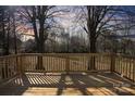 Relaxing wooden deck offering a serene view of the surrounding woods and a beautiful sunset at 5520 Chestnut Dr, Hickory, NC 28602