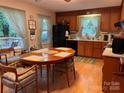 Eat-in kitchen with a large dining table, warm wood cabinetry, and plenty of natural light from the windows at 5806 Whitingham Dr, Charlotte, NC 28215