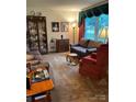 Cozy living room featuring comfortable sofas, a decorative cabinet, and large windows that illuminate the room at 5806 Whitingham Dr, Charlotte, NC 28215