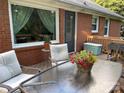 Outdoor patio space with a glass table, comfortable seating, and lush plants, perfect for relaxation at 5806 Whitingham Dr, Charlotte, NC 28215