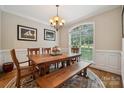 Inviting dining room features a large window, wood table, and beautiful chandelier at 5812 Morgan Park Dr, Monroe, NC 28110